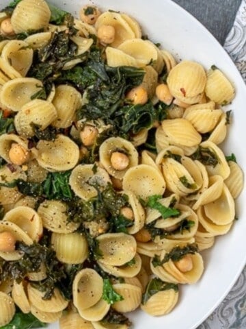 Orecchiette pasta with chickpeas and kale in white dish