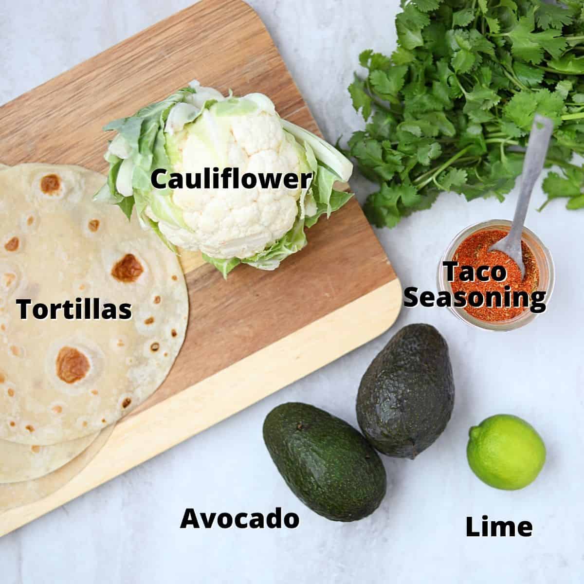 Ingredients labeled for cauliflower tacos on white counter. 