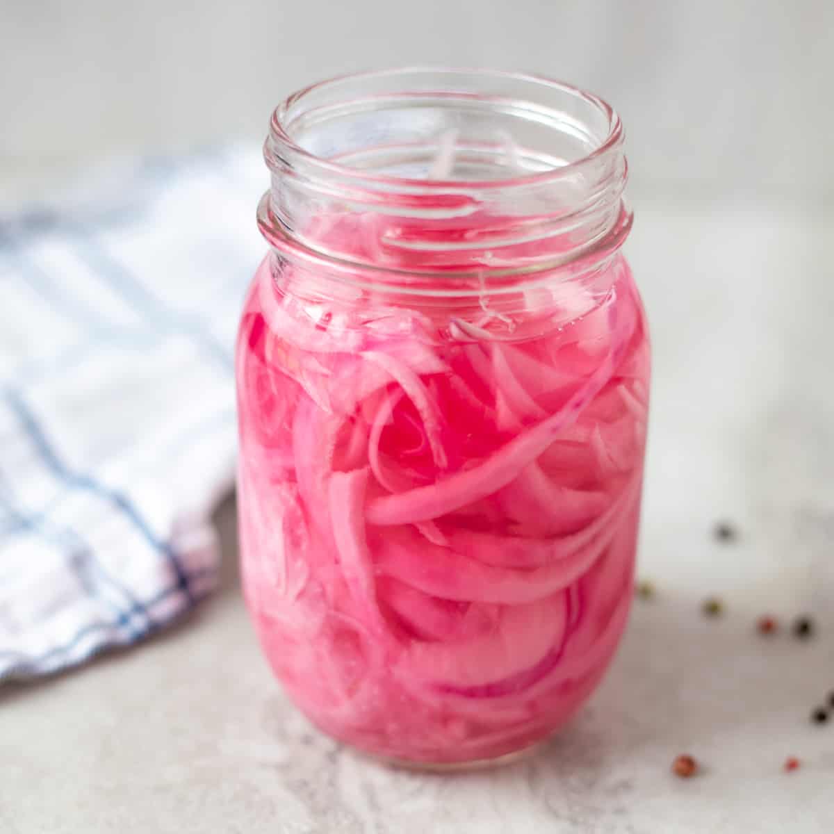 Jar on counter with pickled red onions.