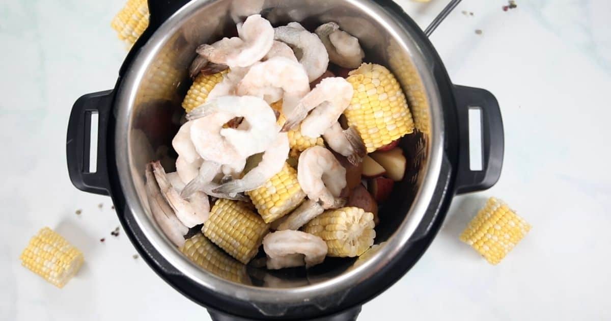 Shrimp on top of corn and potatoes in the instant pot. 