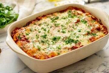 Baked Ravioli in casserole dish topped with minced parsley.