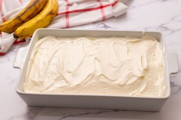 Cream Cheese Frosted Banana Cake in white cake pan.