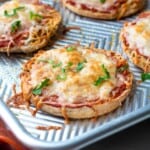 Baked cheese English Muffin Pizza on baking sheet.
