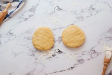 Two disks of homemade pie crust on floured work surface.