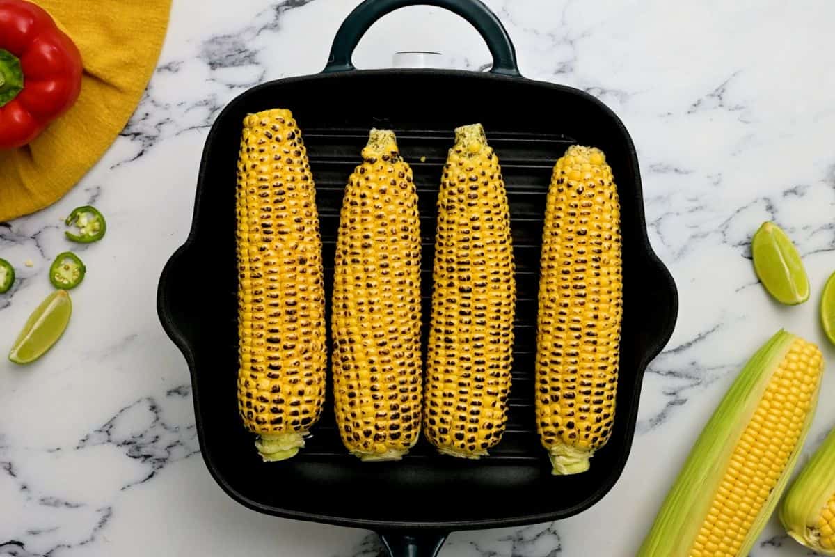 Fresh corn on the cob on a grill plate.
