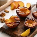 Grilled Cinnamon Sugar peaches on wooden cutting board.