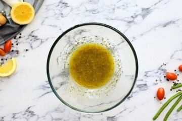 Homemade Italian dressing in clear bowl after being whisked together.