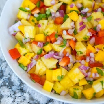 Close up of pineapple mango salsa in white bowl.