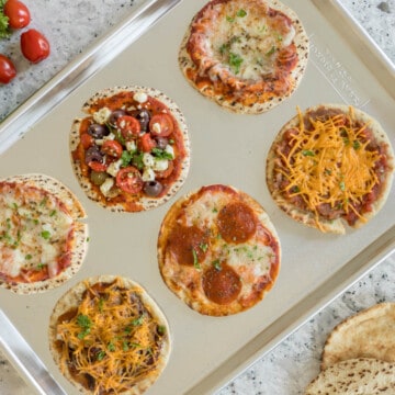 4 varieties of Baked Pita Bread Pizza on sheet pan.