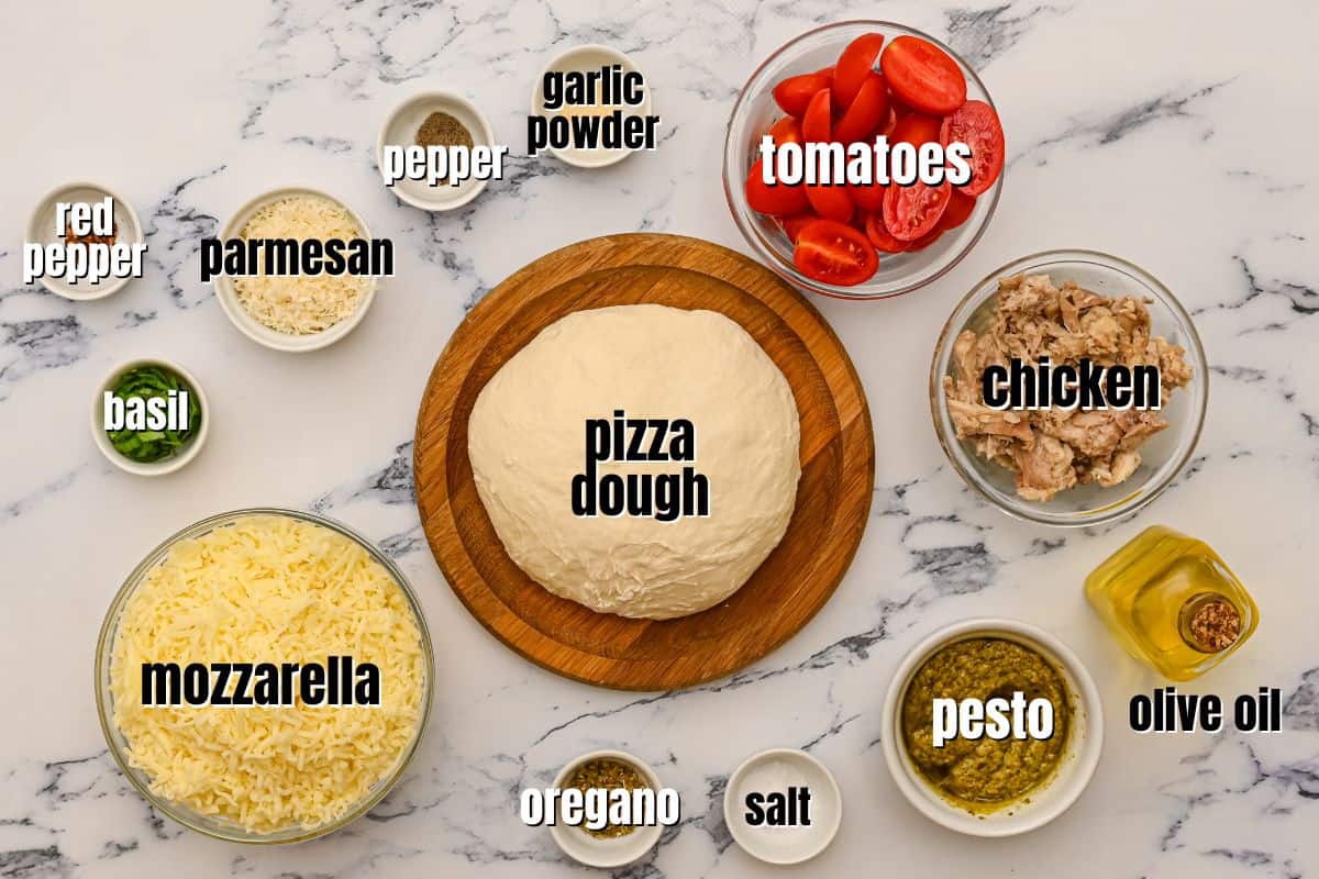 Ingredients for pesto pizza labled on counter.