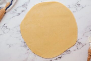 Pie dough rolled out into 12-inch circle on floured work surface.