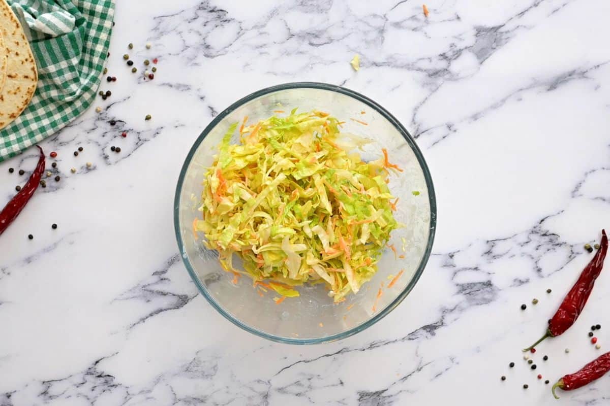 Lettuce, carrots and ranch dressing tossed together in medium mixing bowl.
