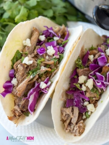2 pork tacos made with slow cooker carnita meat topped with red cabbage.