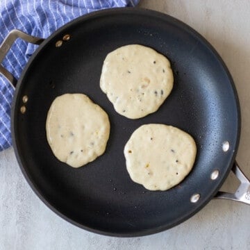 3 chocolate chip pancakes in skillet.
