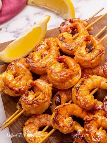 Grilled shrimp on wooden cutting board.