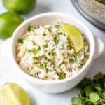 Bowl of cilantrol lime rice next to fresh limes and the Instant Pot.