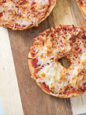 Bagel Pizza on wooden cutting board.