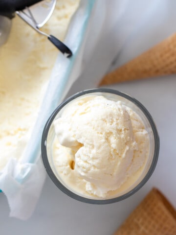 Dish of vanilla ice cream next to loaf pan with no churn ice cream.