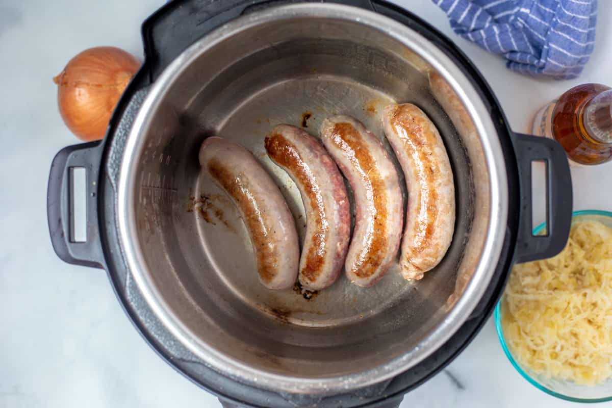 Browned brats in inner pot of Instant Pot. 