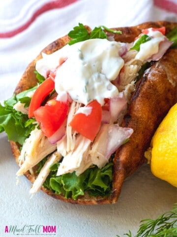 Pita filled with greek chicken, tomatoes, and tzatziki sauce.