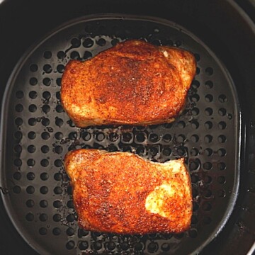 AIr fried pork chops in air fryer basket.