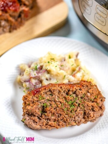 Meatloaf with mashed potatoes on white plate next to Instant Pot.