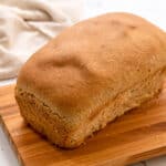 Loaf of wheat bread on cutting board.