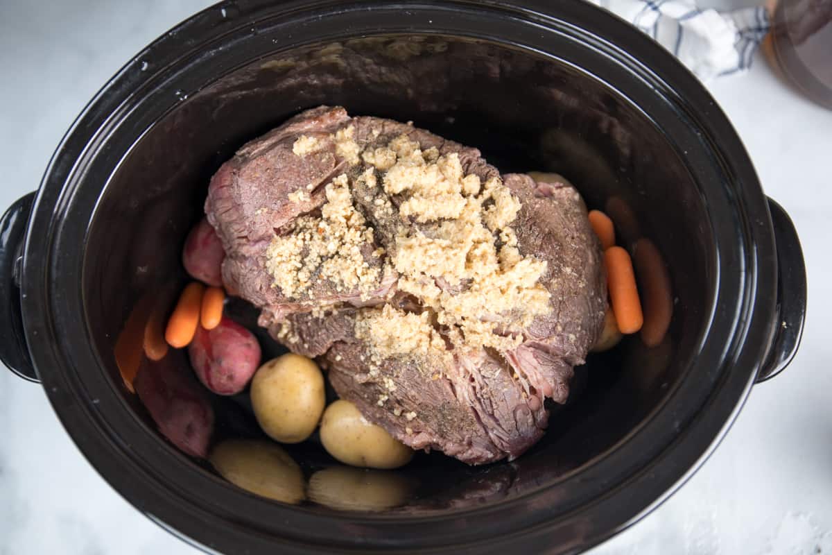 Pot roast in slow cooker with carrots and potatoes. 