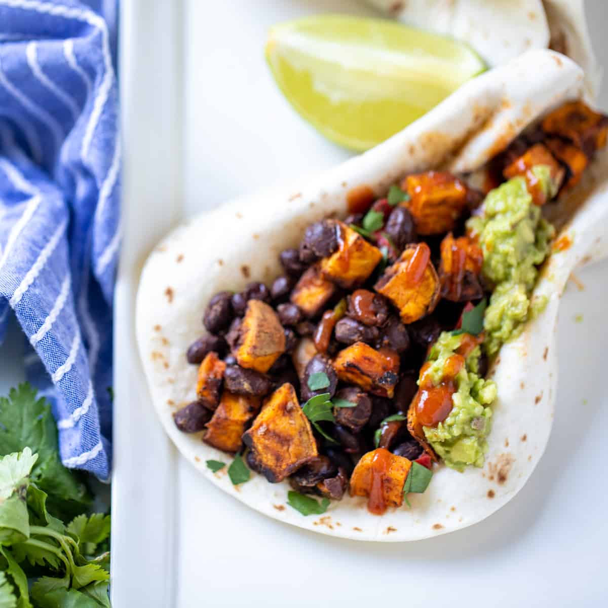 flour tortilla filled with sweet potatoes, black beans, and guacamole.