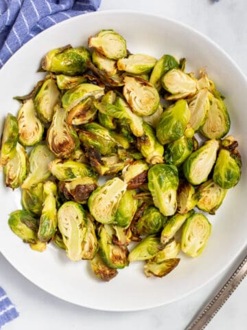 Air fried Brussels Sprouts in white bowl.