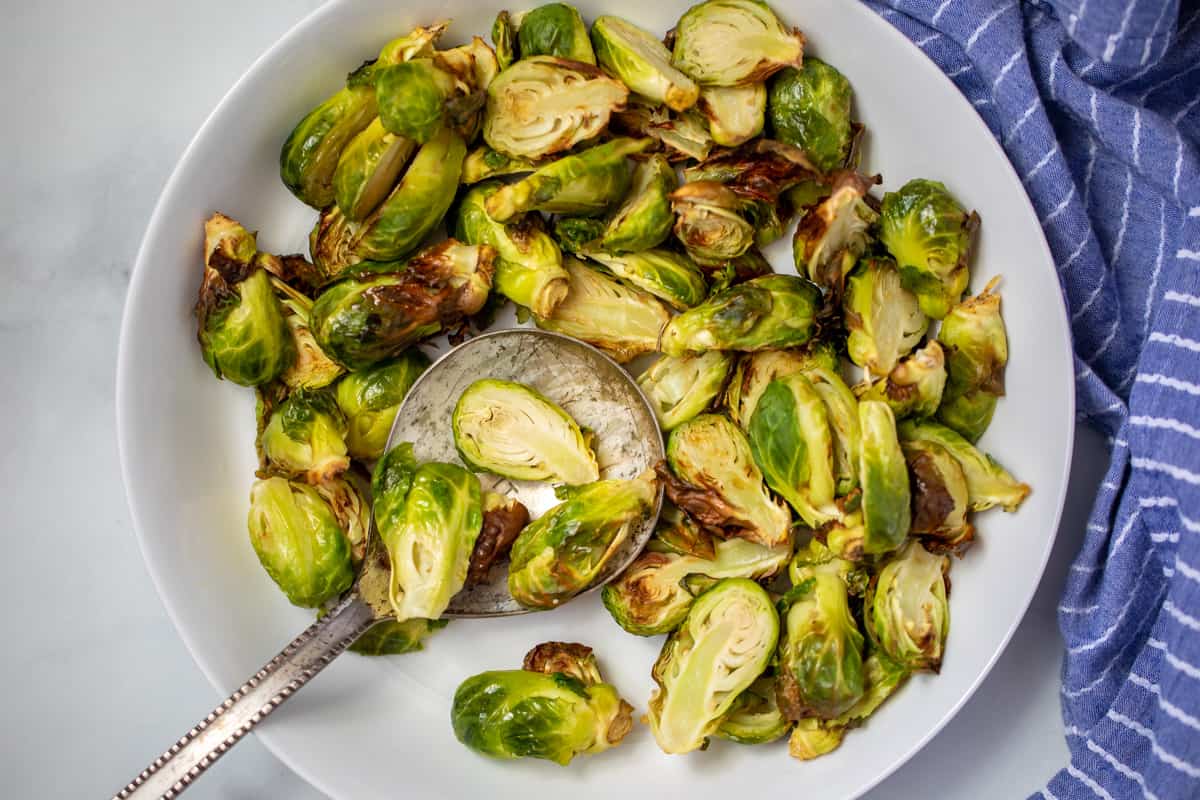 White bowl with crispy air fried Brussels Sprouts.