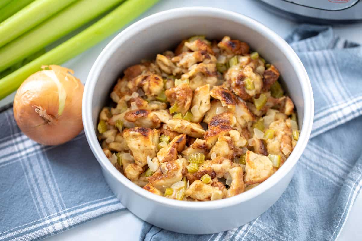 Browned stuffing in cake pan next to instant pot and celery.