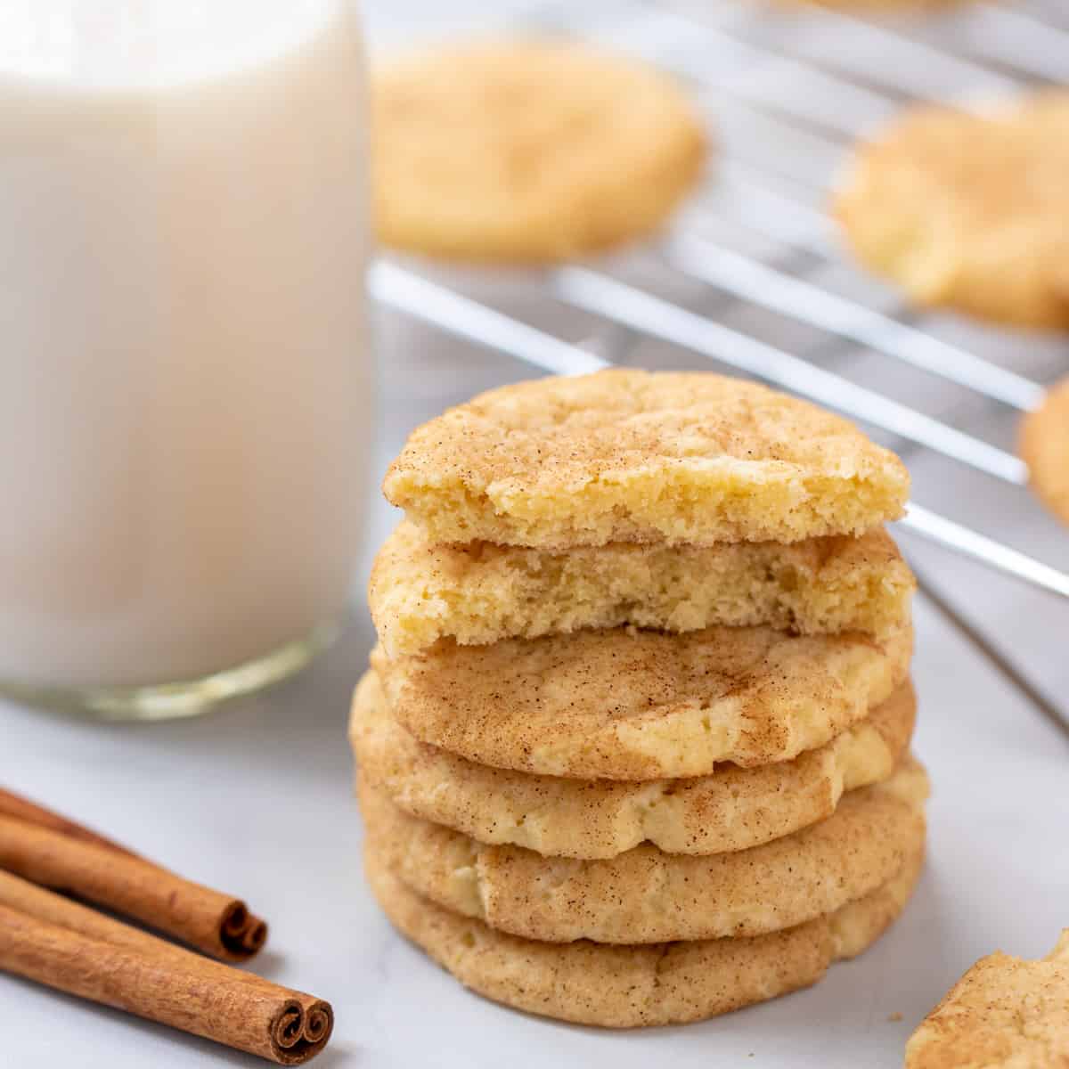 Stack of snickerdoodle cookies next to glass of milk.