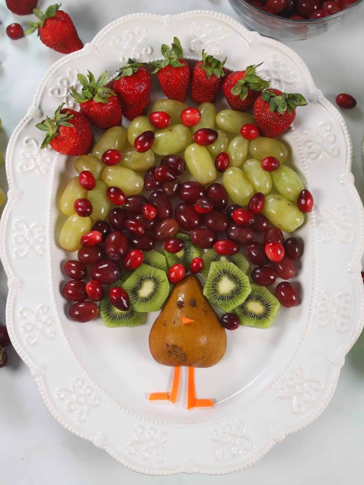 Fruit arranged to look like the feathers of a turkey coming out of pear.