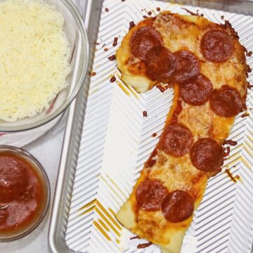 Candy Cane Shaped Pepperoni Pizza on baking sheet.