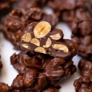 Chocolate covered nut cluster cut open to reveal peanuts.