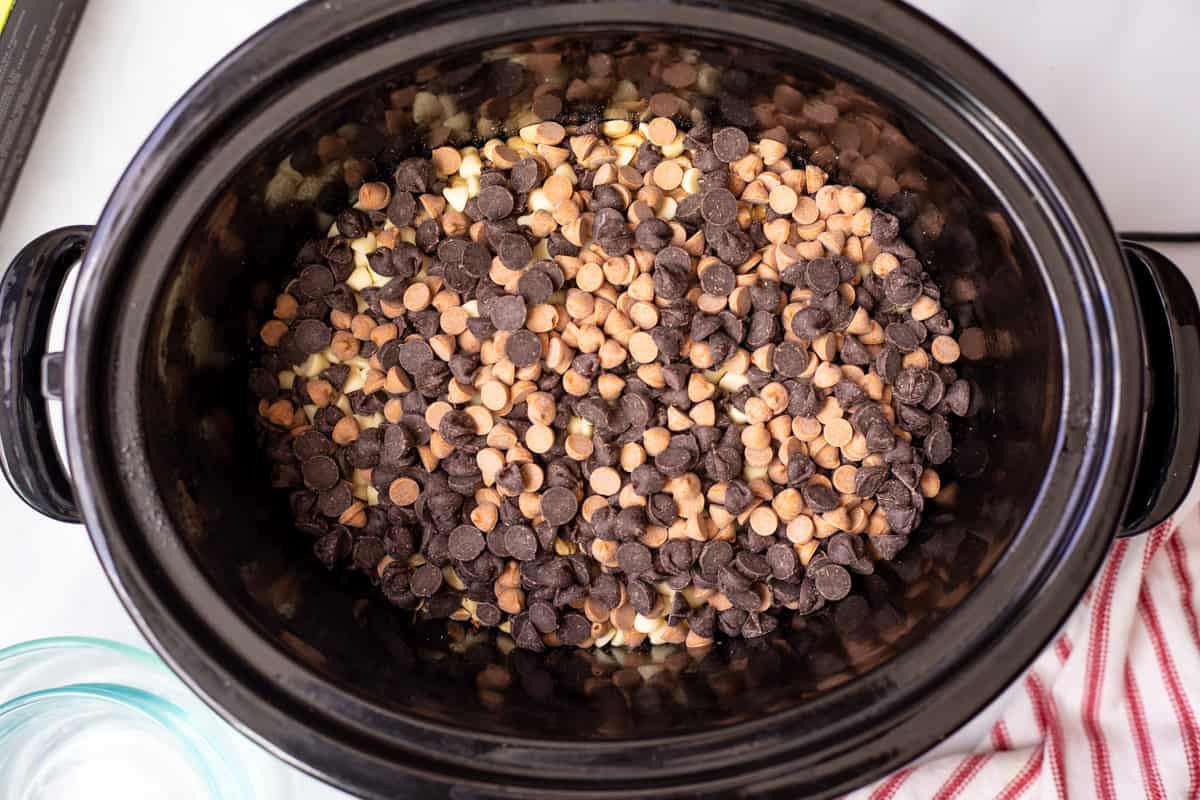 Peanuts and 4 kinds of chocolate layers in a crockpot.