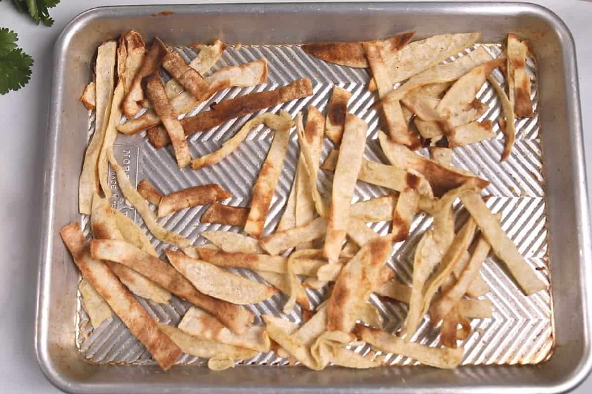 Toasted tortilla strips on a rimmed baking sheet.