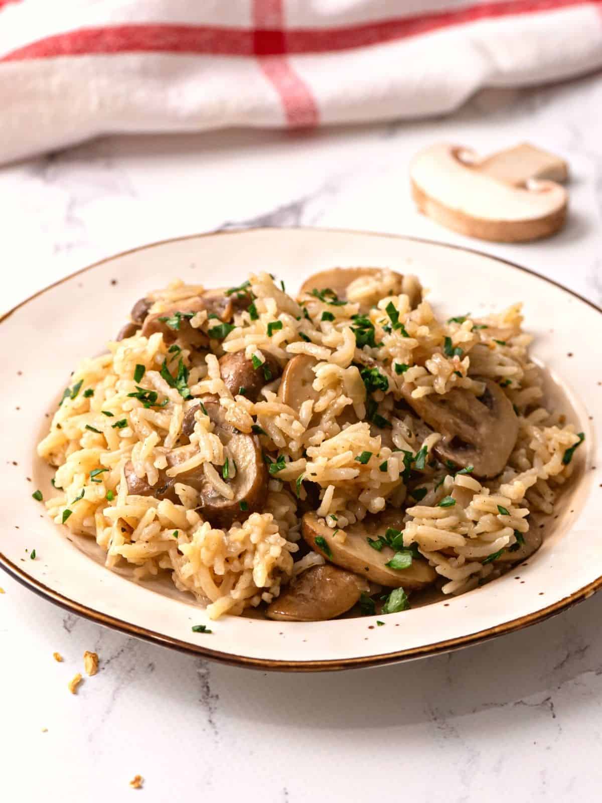 Rice Pilaf in white bowl with mushrooms and parsley.
