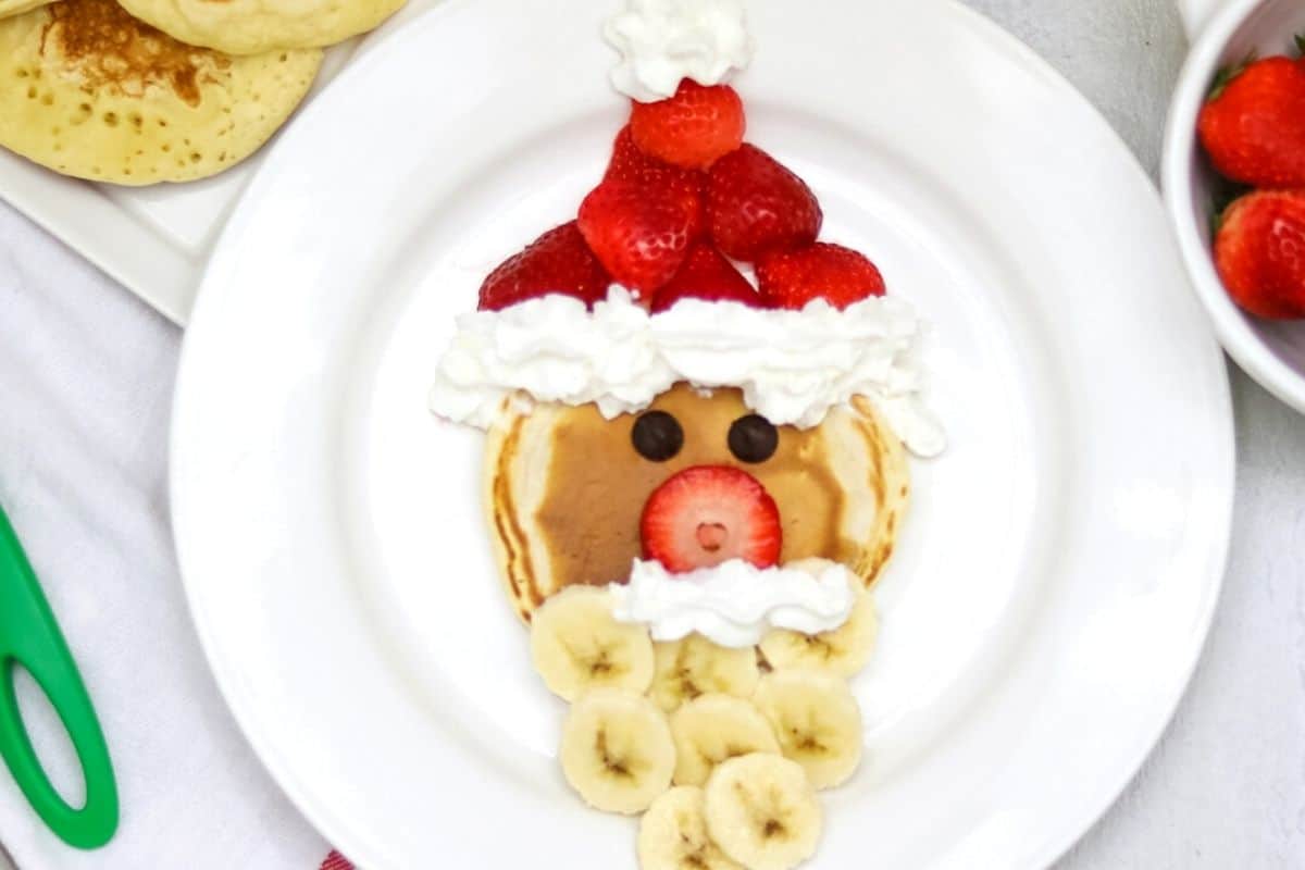 Pancakes with strawberry hat and banana beard to form Santa.