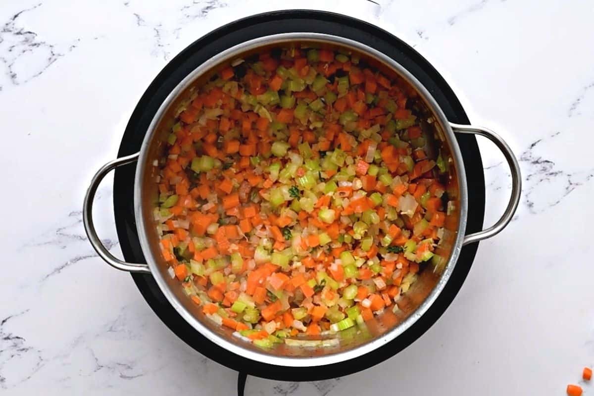 Sauteed veggies in stock pot for chicken orzo soup recipe.