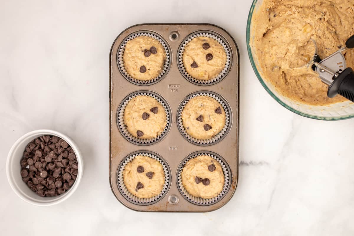 Banana Peanut Butter Muffins in muffin tin topped with chocolate chips.