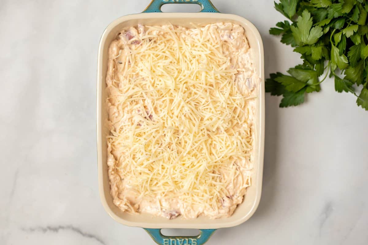 Reuben Dip in casserole dish topped with shredded cheese.