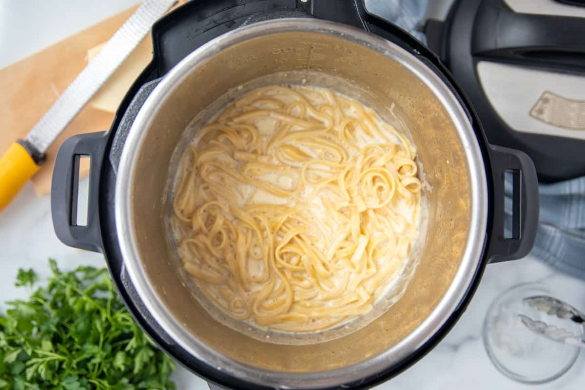 Cooked fettuccine noodles in the inner pot of the instant pot. 