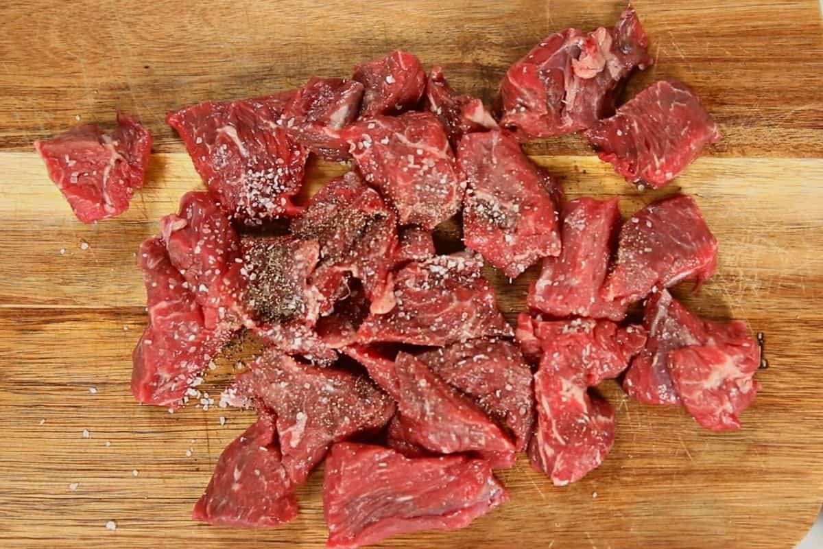 Seasoned Stew meat on cutting board.
