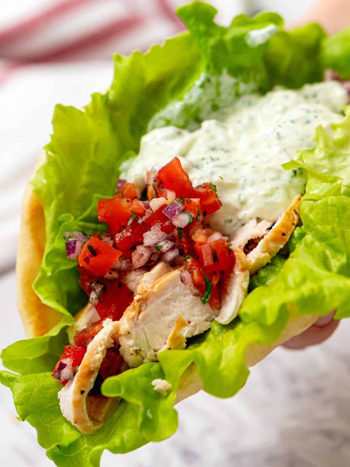 Chicken Gyros are an easy, wholesome meal that is packed full of flavor! Warm pita bread is stuffed with tender yogurt-marinated Greek chicken, fresh tomatoes and onions, and Tzatziki sauce to create a Greek Chicken Gyro that is sure to become a favorite go-to recipe.