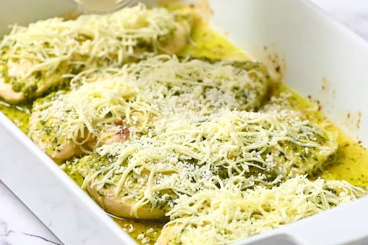 Baked pesto chicken topped with parmesan and mozzarella.