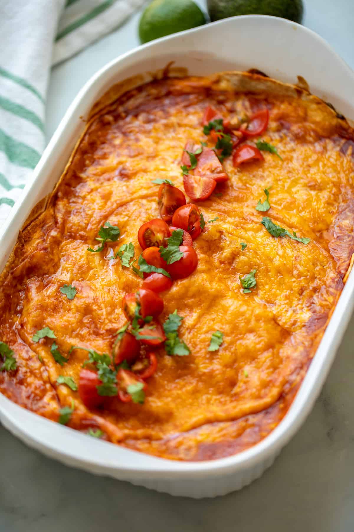 Baked Chicken Enchilada casserole topped with cilantro and grape tomatoes.