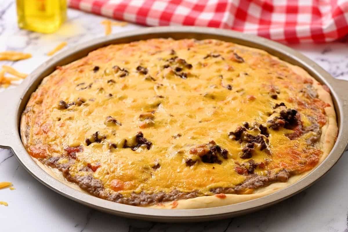 Baked taco pizza on pizza pan.