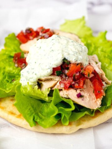 Pita topped with grilled greek chicken, lettuce, tomatoes, and Tzatziki sauce.